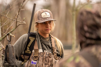 Pocket Badge Trucker Hat - Mossy Oak Bottomland